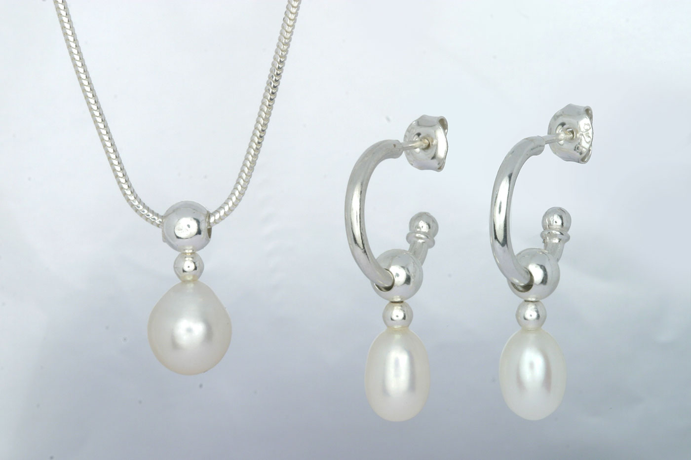 Korvakorut 3112, 3/4 rengas 14/2mm, tappi 0.9/10mm. Aidot makeanveden helmet 6x8mm, väri: valkoinen.  Hinta: 29€<br/>
							Riipus 5112, 16mm. Aito makeanveden helmi 7x9mm, väri: valkoinen.   Hinta: 19€<br/>
							925 hopeaa<br/>
							Hopeinen käärmeketju 1.2mm, 45cm. Hinta: 14€